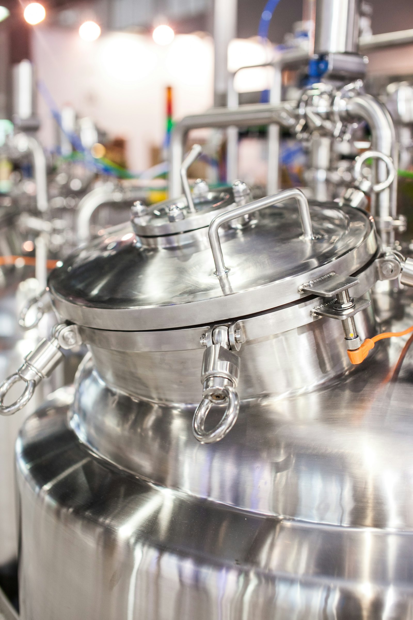 Close-up of a stainless mixing tank lid and fittings